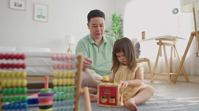 A cheerful kid girl playing with colorful toys with loving dad in house.