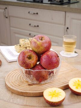 Fresh Red Apples in Glass Bowl on Kitchen Counter with Sliced Fruit and Tea