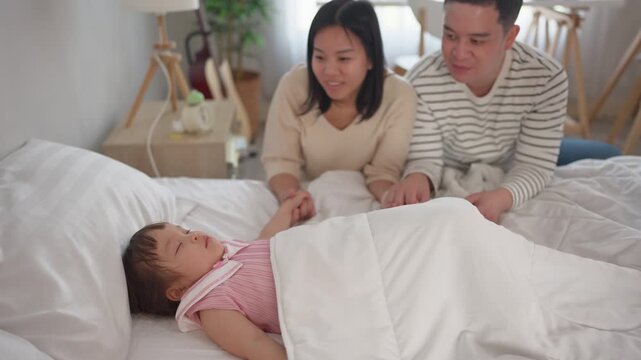 Asian mature parents lovingly care for and raises baby girl at home. 