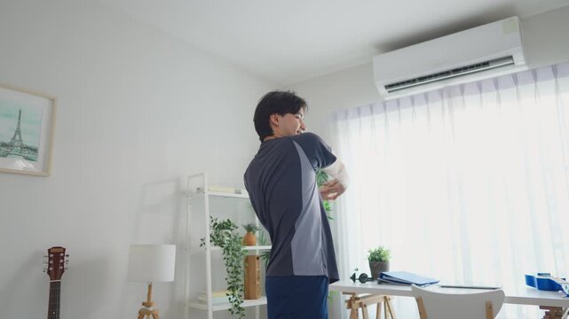 Asian young handsome sportsman excercise in cozy living room at home. 