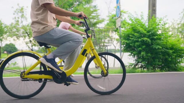 Close up of couple dating and biking together on a road in the park. 