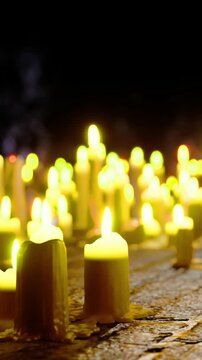 Warm candlelight fills the dark ambiance, creating a peaceful glow. Each candle stands tall, gently flickering, casting soft shadows as tranquility envelops the surroundings.