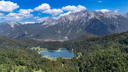 Obraz premium Aerial drone view of beautiful alpine Ferchensee lake surrounded by green forests and mountain peaks, nature landscape of Bavarian Alps, Germany