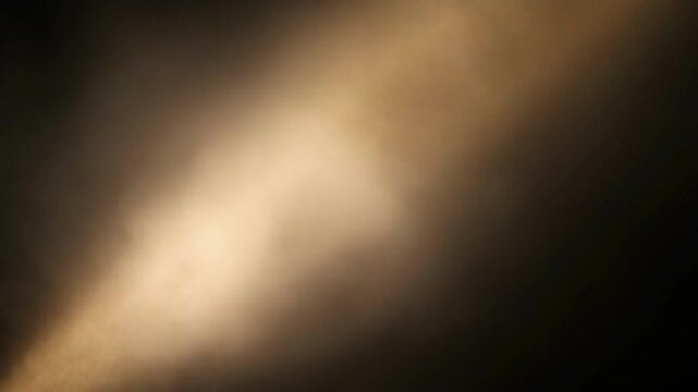 Abstract blurred light and shadow gradient with warm tones on dark background
