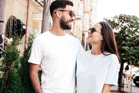 Smiling beautiful woman and her handsome boyfriend. Woman in casual summer jeans clothes. Happy cheerful family. Female having fun. Sexy couple posing in the street at sunny day. In sunglasses