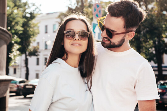 Smiling beautiful woman and her handsome boyfriend. Woman in casual summer jeans clothes. Happy cheerful family. Female having fun. Sexy couple posing in the street at sunny day. In sunglasses