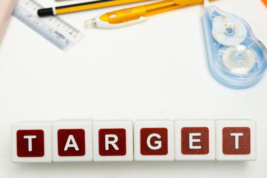 Business organization and administration concept featuring letter blocks spelling &ldquo;TARGET&rdquo; on a clean office desk, surrounded by office stationaries.