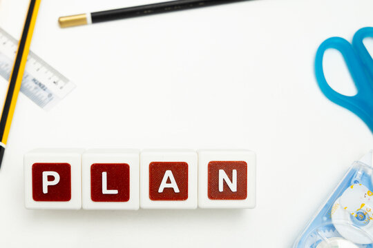 Business organization and administration concept featuring letter blocks spelling &ldquo;PLAN&rdquo; on a clean office desk, surrounded by office stationaries. Symbolizing corporate mission, strategic planning, b