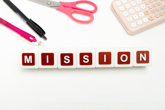 Business organization and administration concept featuring letter blocks spelling &ldquo;MISSION&rdquo; on a clean office desk, surrounded by office stationaries.