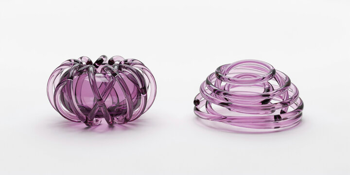 Two decorative sculptural made of translucent purple glass on white surface