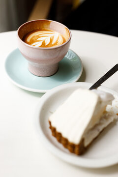Cup of hot latte coffee on table by the window.