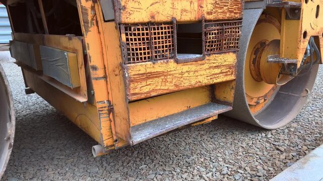 Close view of heavy road roller steel drum and machinery