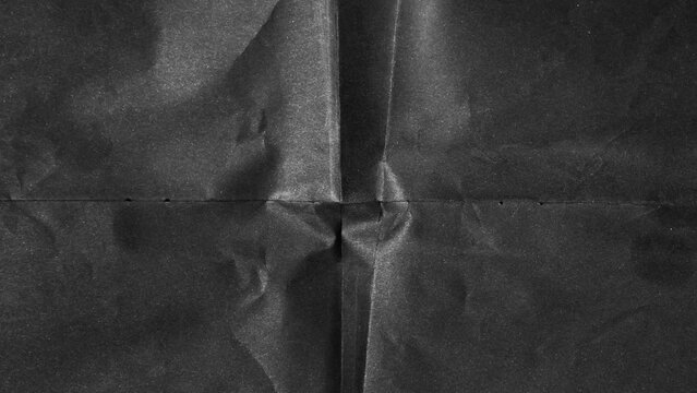 Black paper background with creases that separates paper symmetrically into four parts