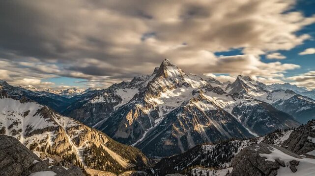 Time lapse of fast moving clouds over snow capped mountain peaks in Alps