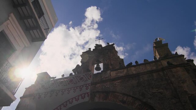 Pigeons sit on Historic Capilla del Cristo in Old San Juan, Puerto Rico - Tilt Down to Reveal with Lens Flare - UHD 4K