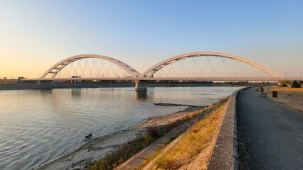 Naklejka premium low water level of Danube River at golden hour in Novi Sad, with view over Žeželj Bridge