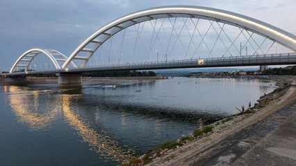 Naklejka premium low water level of Danube River at golden hour in Novi Sad, with view over Žeželj Bridge