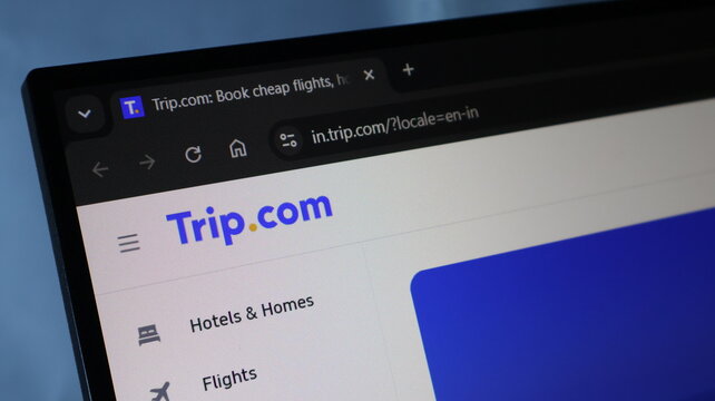 Trip com travel booking website homepage on dark laptop monitor screen.