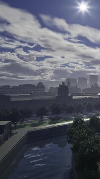 A captivating skyline emerges as city buildings stand tall beneath a sky filled with swirling clouds. Early morning light dances along the waterfront and lush greenery thrives nearby.