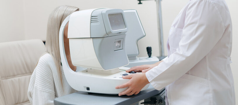 Female patient seated for autorefractor eye test in clinic room Ophthalmologist doctor
