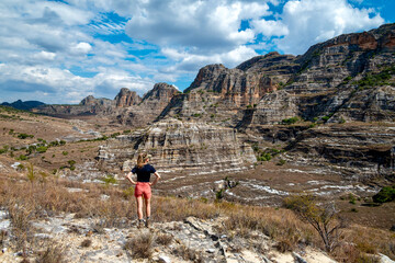 Fototapeta premium Woman Hiker Overlooking Dramatic Isalo Sandstone Canyon, Madagascar