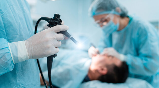 Surgeon performing endoscopy procedure with specialized equipment in operating room