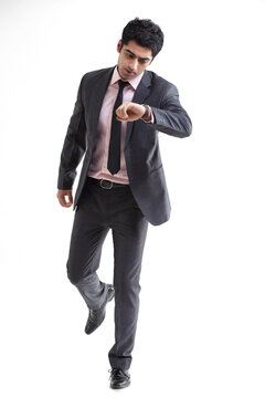Handsome businessman checking time over white background 