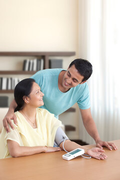 Mother and son looking at each other while measuring blood pressure 