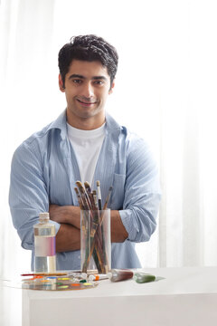 Handsome male painter with arms crossed in art studio 