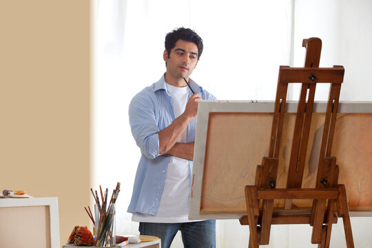 Thoughtful male painter in studio looking for inspiration 