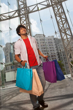 Handsome young man smiling with shopping bags 