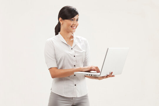 Portrait of confident young businesswoman holding laptop 