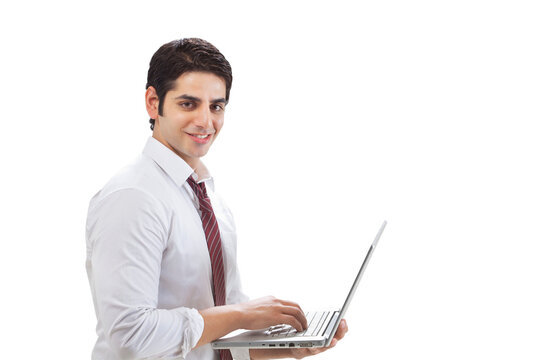 Portrait of young businessman using laptop on white background 