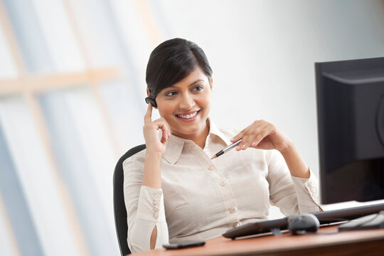 Female executive talking on a blue-tooth headset 