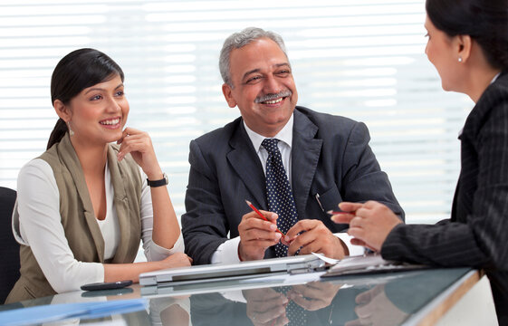 Smiling male and female professionals discussing in meeting 