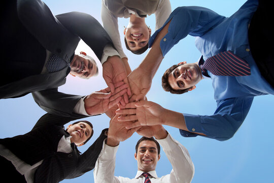 Low angle view of business people stacking hands 