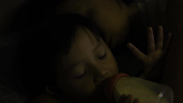 Mom Sleeping While Baby Drinks From Bottle