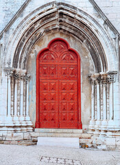Fototapeta premium Bright red Gothic church door in stone archway