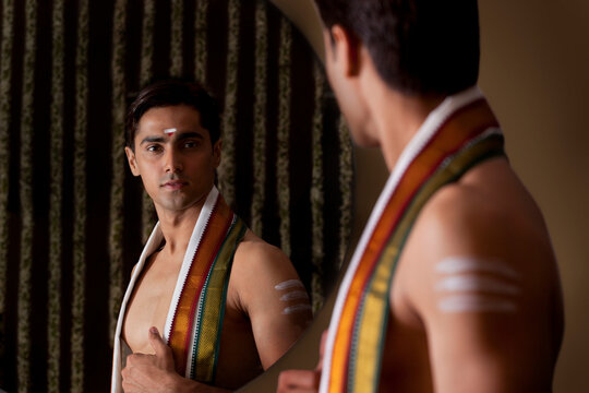 Young man looking at self in mirror 