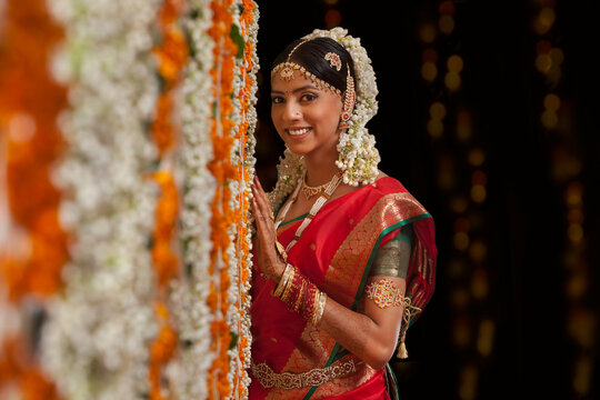 Bride standing by garlands 