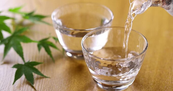 冷酒をガラスのお猪口に注ぐ