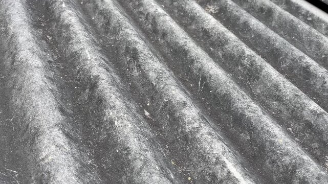 Old corrugated asbestos roof texture in bright daylight