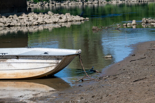 Small Boat Resting on Muddy Shore of Low Water