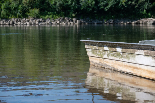Small Boat Resting on Muddy Shore of Low Water