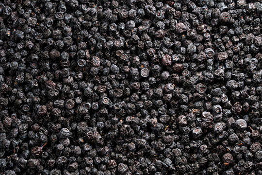 Top view of dehydrated black blueberries, closeup. Healthy organic superfood background. Concept of ophthalmology health, natural vitamins, food ingredients, drying fruit, or dietary supplement