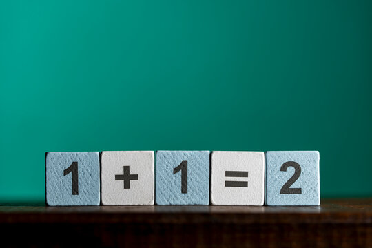 Basic arithmetic addition equation on blocks, closeup. Concept of early education, elementary math, logic, simplicity, problem solving, business synergy, teamwork, or straightforward solution