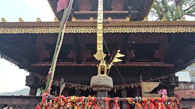 Footage of the historic Manakamana Temple in Nepal, showcasing its traditional multi-tiered pagoda-style architecture, ornate golden roof decorations, intricate wood carvings, and surrounding heritage