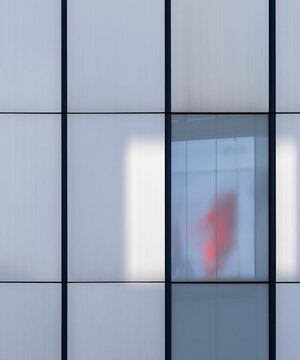 Brushed steel and glass station cladding with a blurred red reflection, featuring a cool metallic texture for transport and travel backgrounds