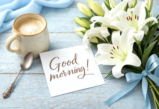 Beautiful good morning setup with white lilies coffee and handwritten greeting card on rustic table