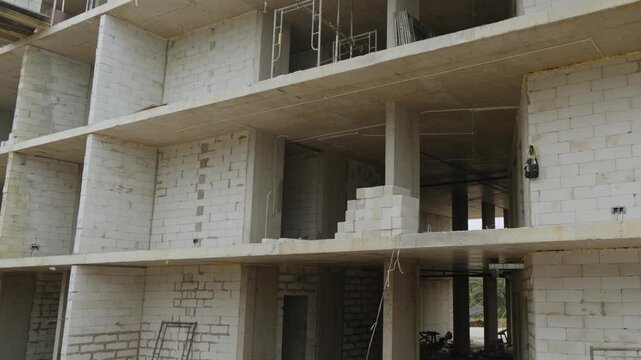 Construction progress of a modern concrete building. Reinforced concrete structure under development, showing structural framework and ongoing construction work.